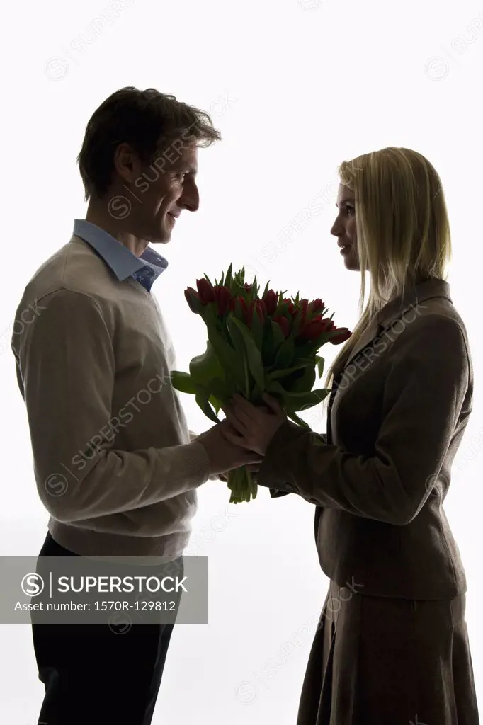 A man giving a bouquet of tulips to his girlfriend