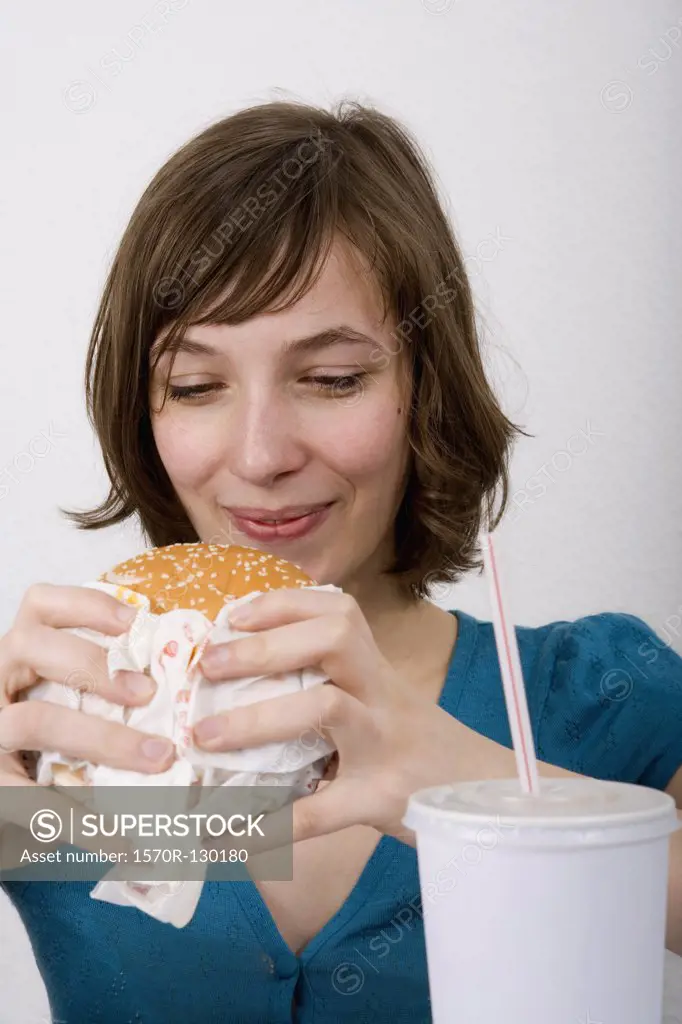 Young woman preparing to eat a burger