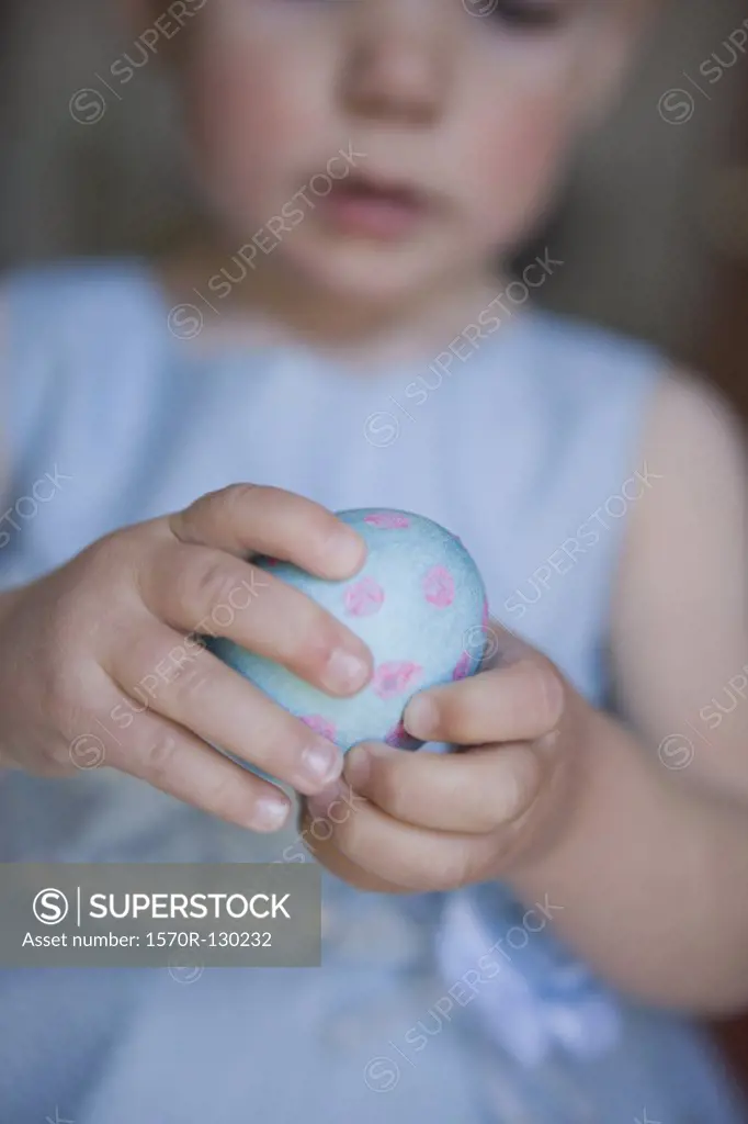 Baby girl holding an Easter egg
