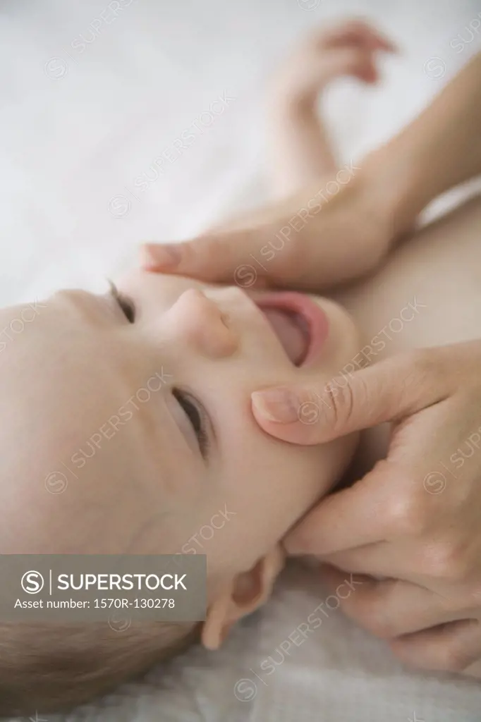Mothers hands on babys face