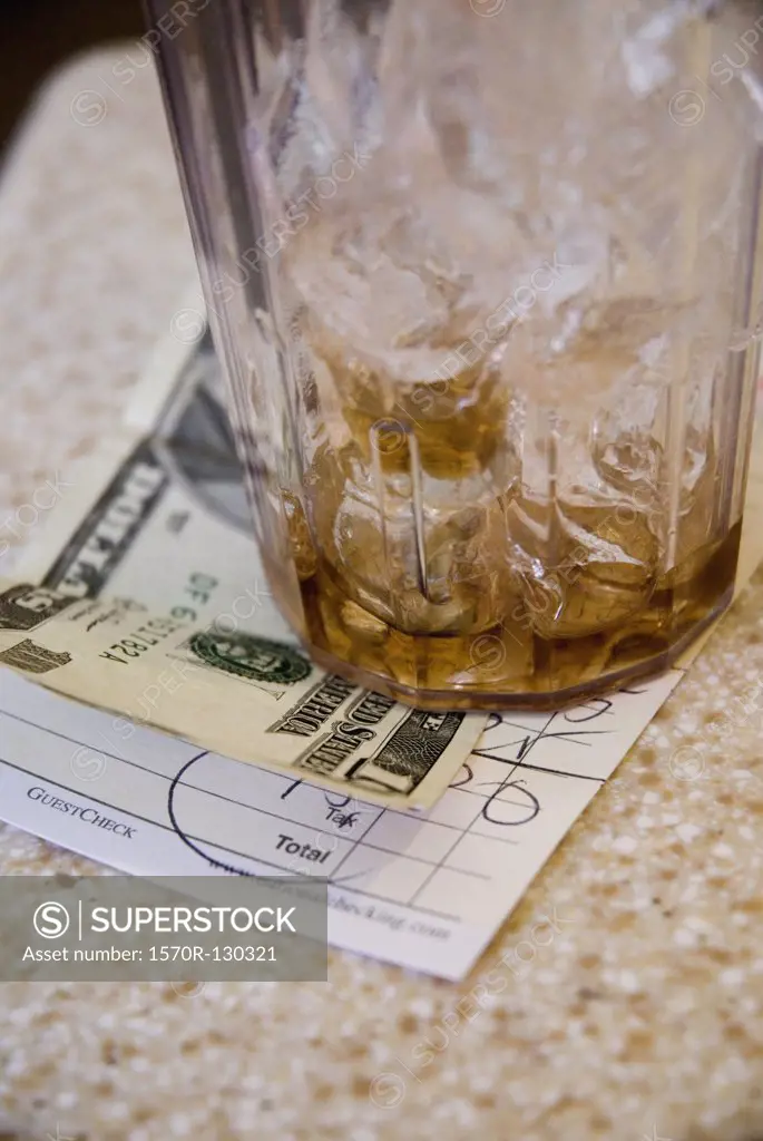 A glass of ice and tip on a restaurant bill