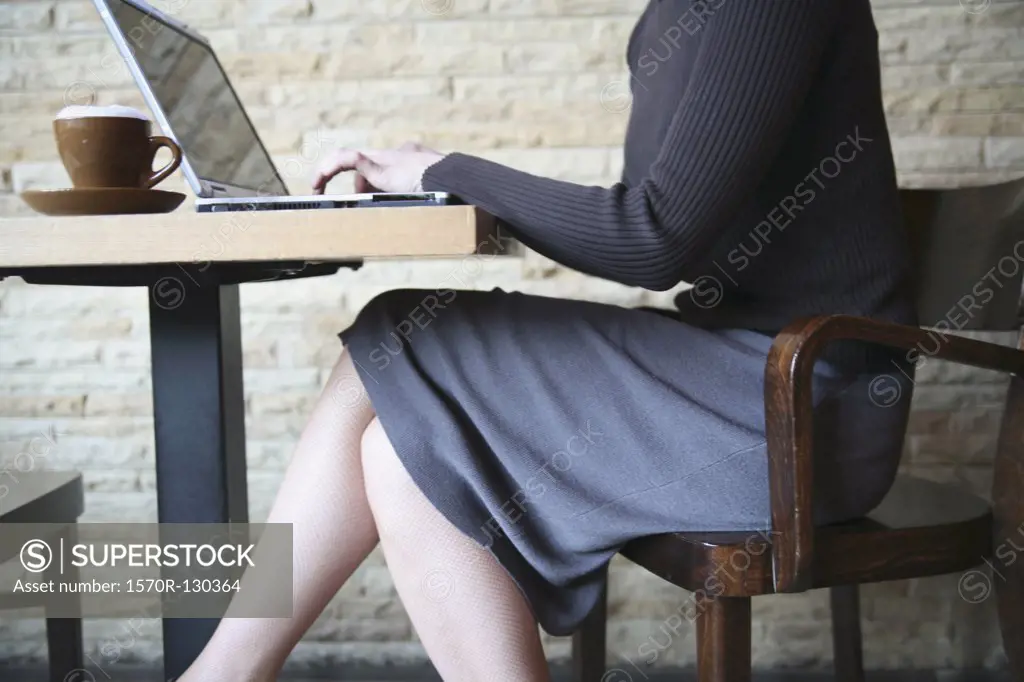 Woman sitting in cafe and using laptop