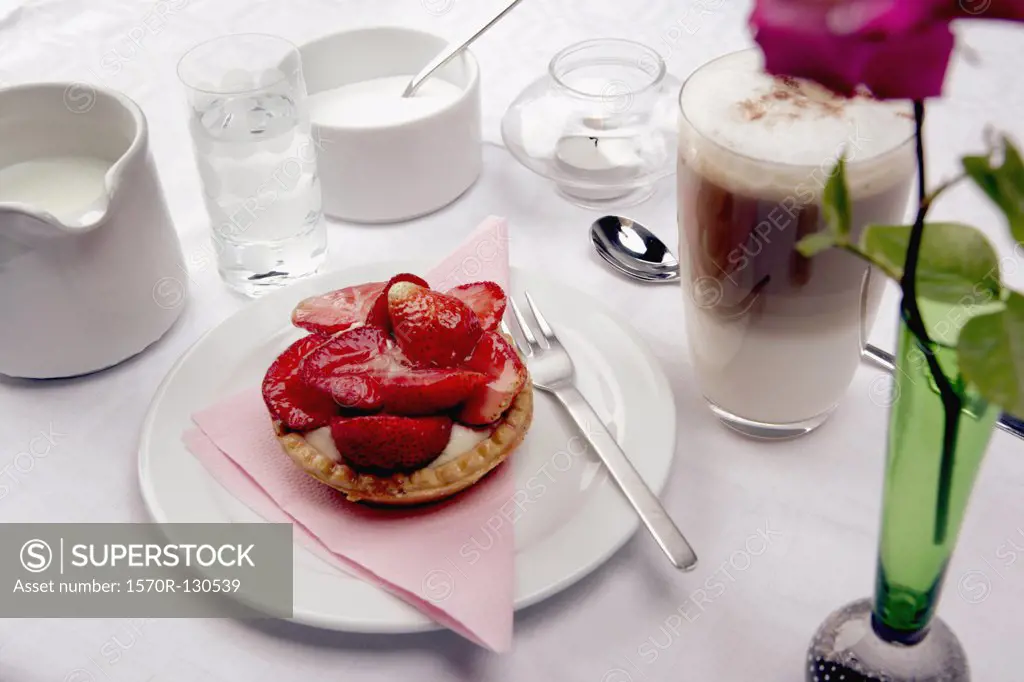 Coffee and strawberry tart on table