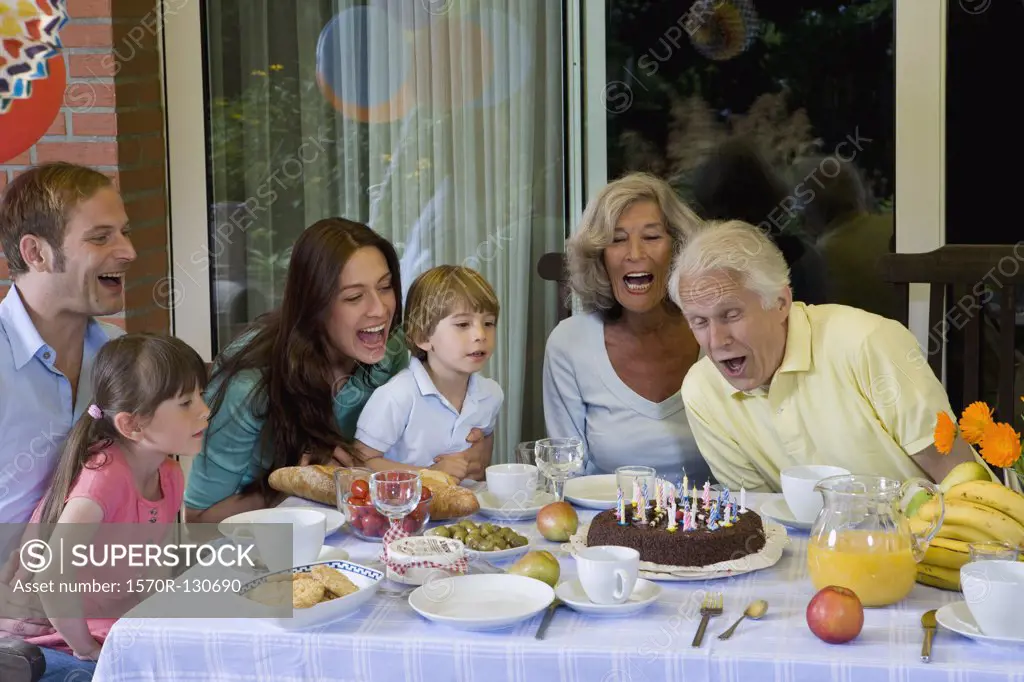 A multi-generational family celebrating a birthday, outdoors