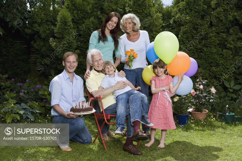 A multi-generational family celebrating a birthday, outdoors