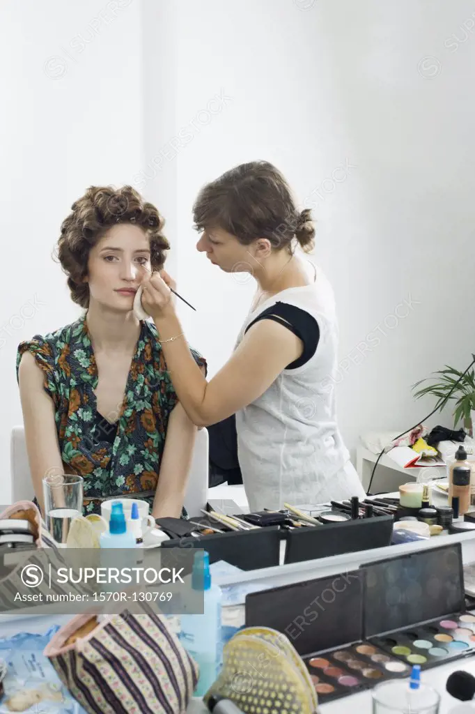 A make-up artist applying make-up on a model