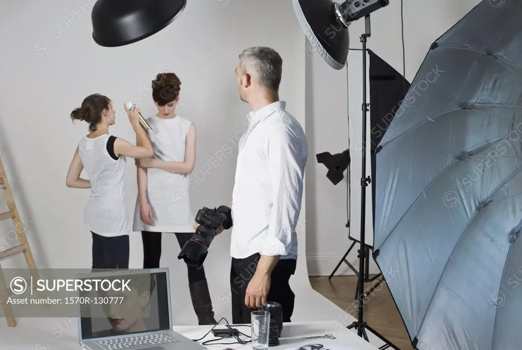 A photographer, model and make-up artist on set of a fashion shoot