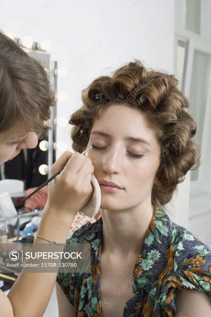 A make-up artist applying make-up on a model