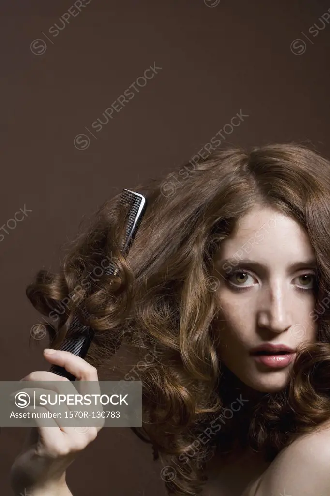 Portrait of a young woman brushing her hair