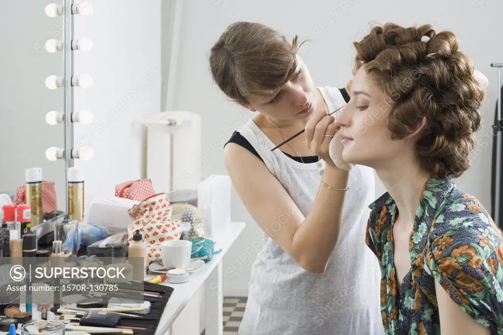 A make-up artist applying make-up on a model