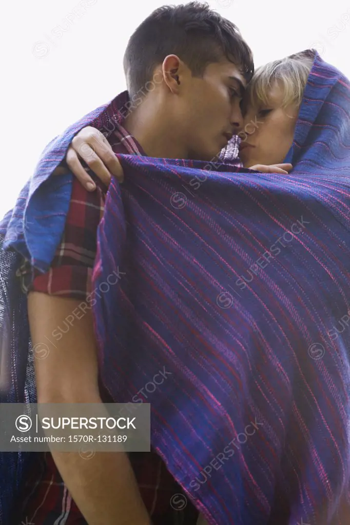 A young couple wrapped in a blanket