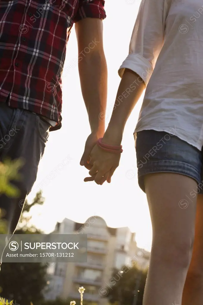 A young couple holding hands in a park