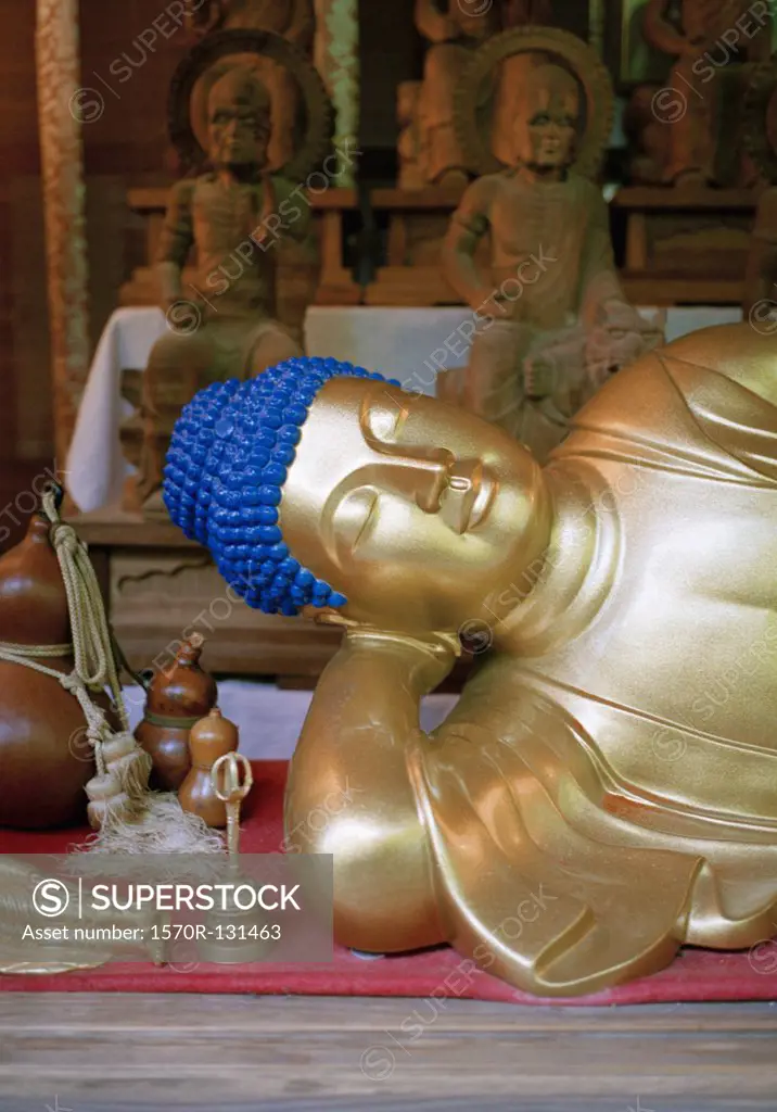 Detail of a gold reclining Buddha statue, Miyajima, Japan