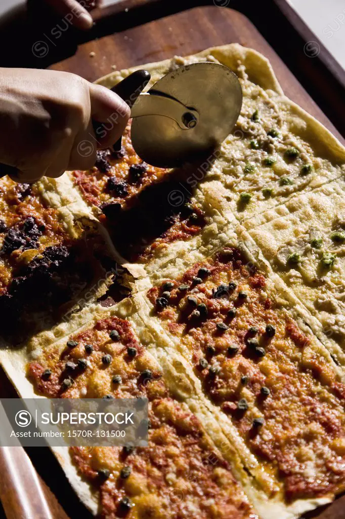 Detail of a pizza being cut