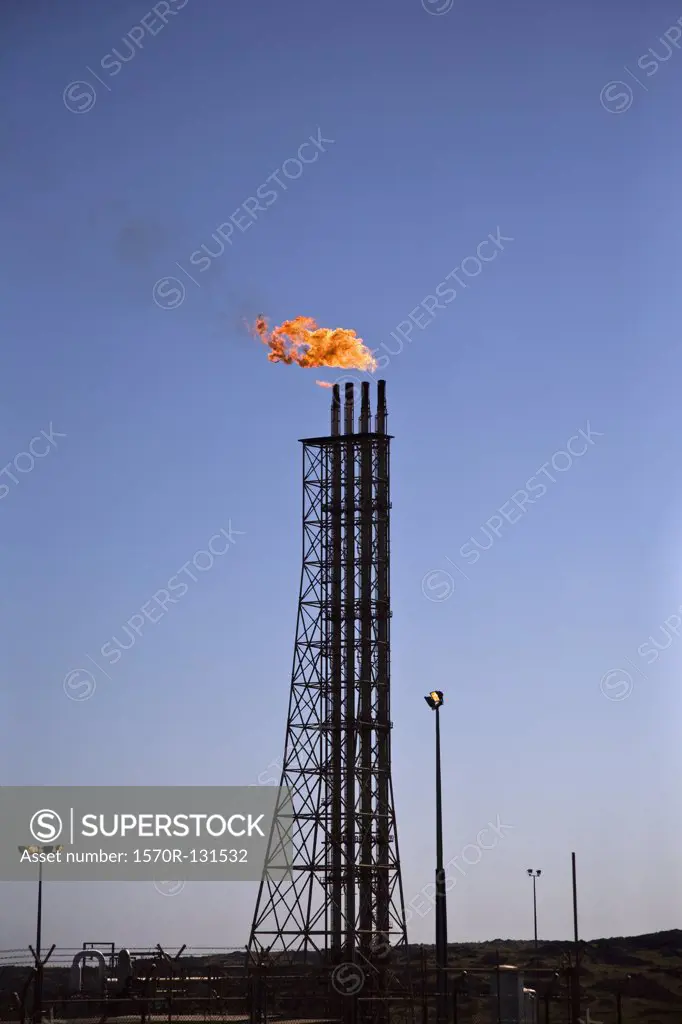 Flame burning above pipes at a fuel refinery, Karatha, Western Australia, Australia