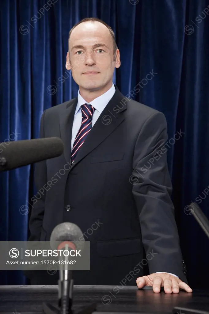 A man in a suit standing at a lectern