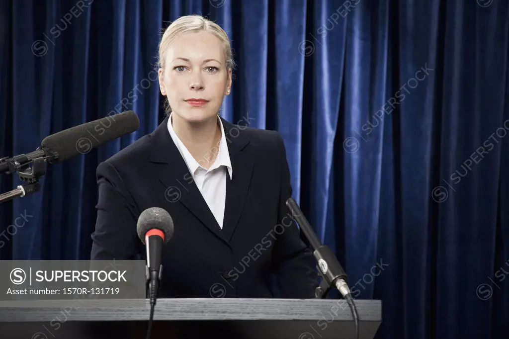 A woman in a suit at a lectern