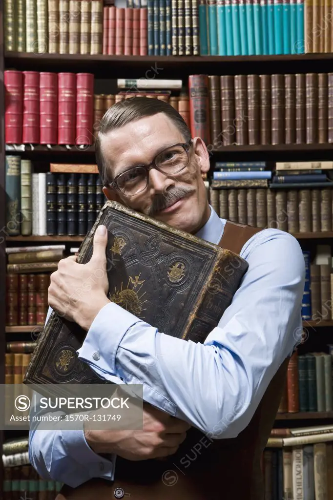 A man holding a book tightly to his chest happily in a bookstore