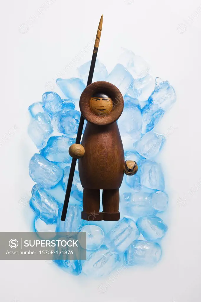 A wooden Inuit figurine on ice cubes