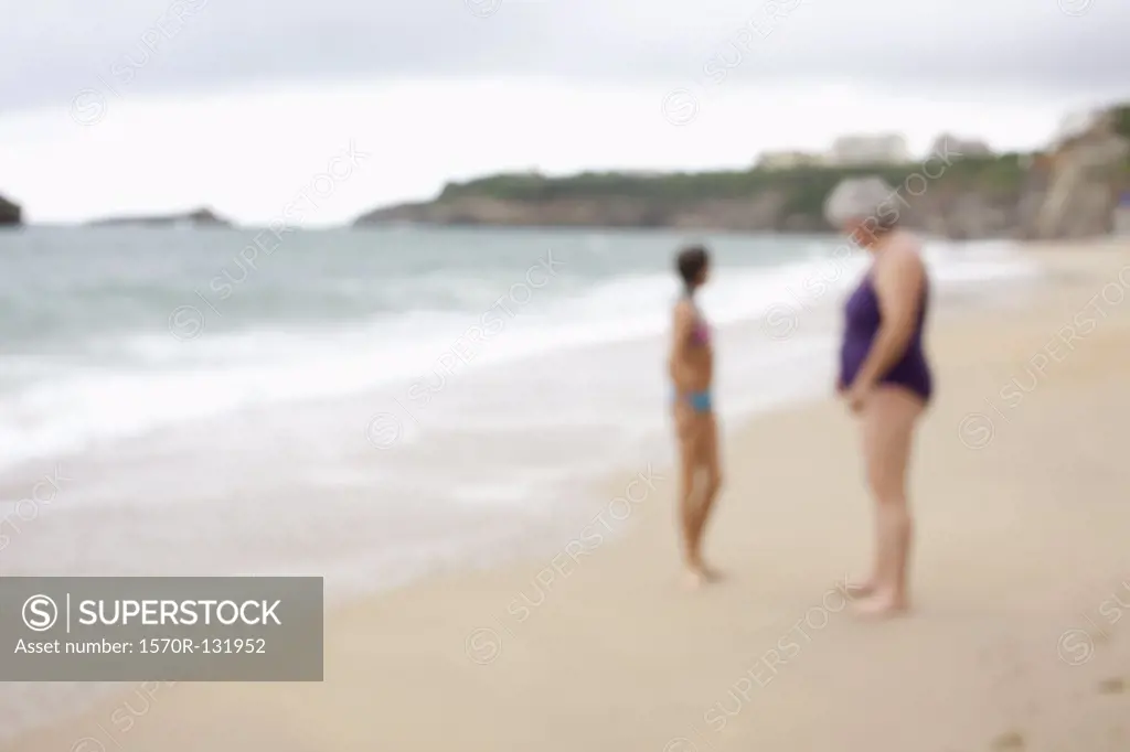 A mother and daughter at the beach, defocused