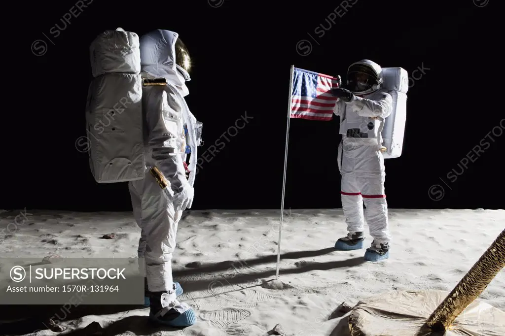 Two astronauts on the moon, an American flag in between them