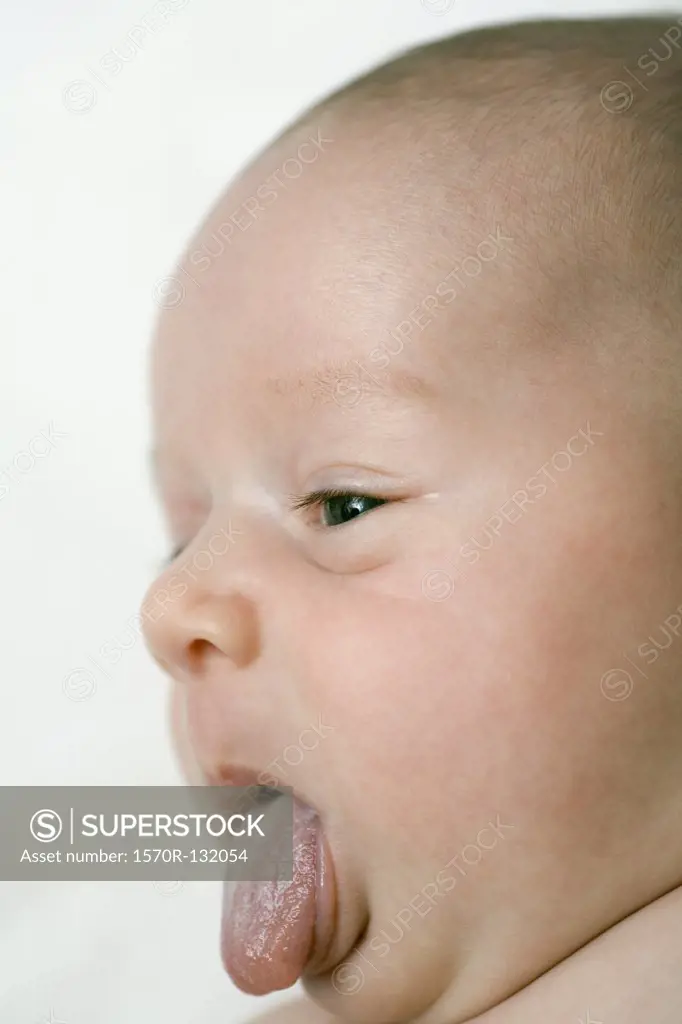 A baby sticking out his tongue, close-up