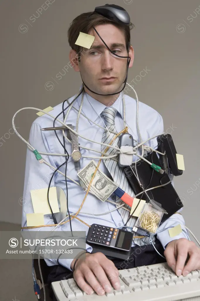 Businessman covered in office supplies