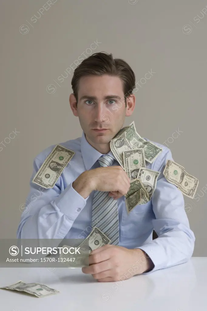 Businessman with money spilling out of his shirt pocket