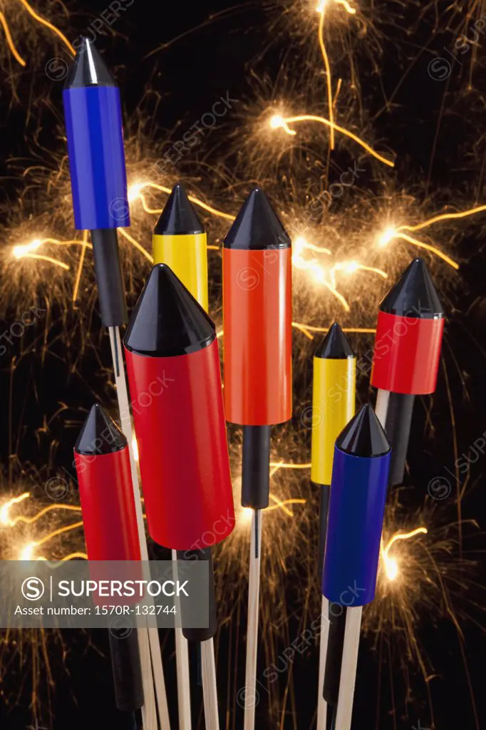 Rocket firecrackers with a firework display behind them