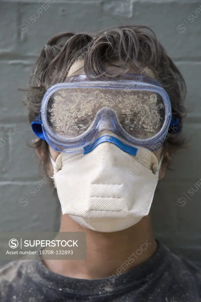 A man wearing protective goggles and a pollution mask, portrait