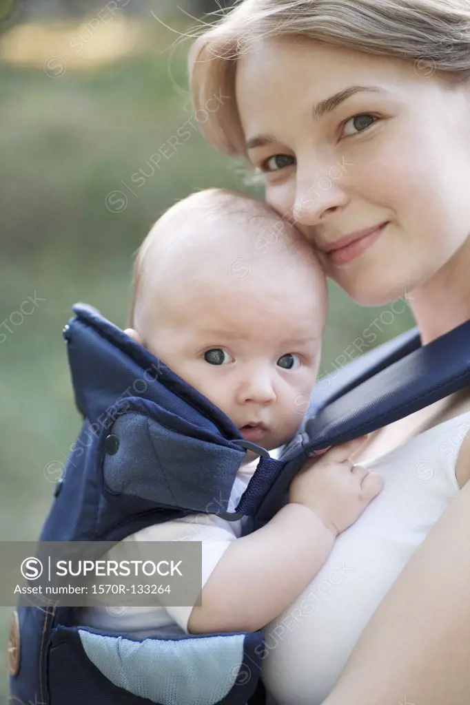 A mother with her baby in a baby carrier, portrait