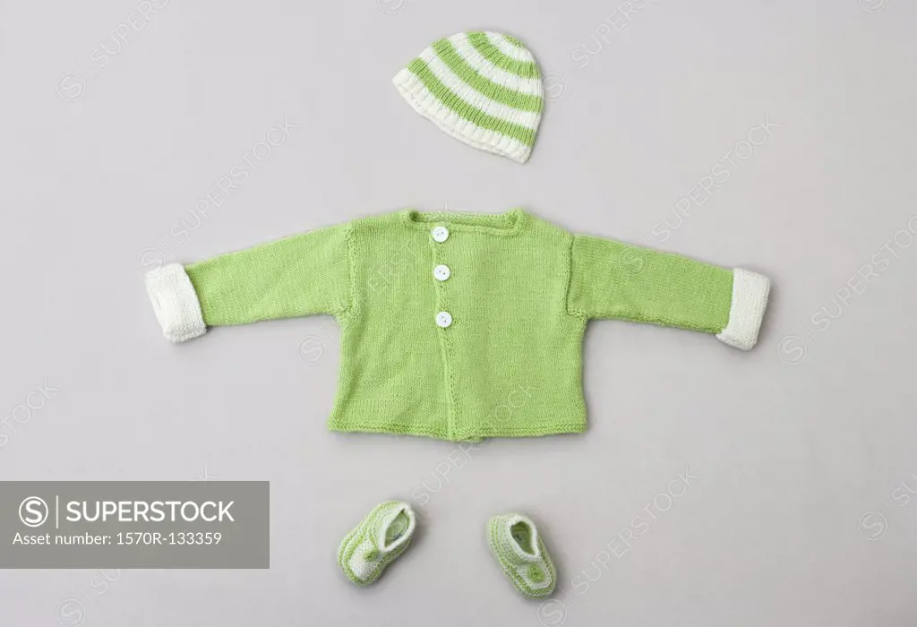 A baby sweater, knit hat and baby booties