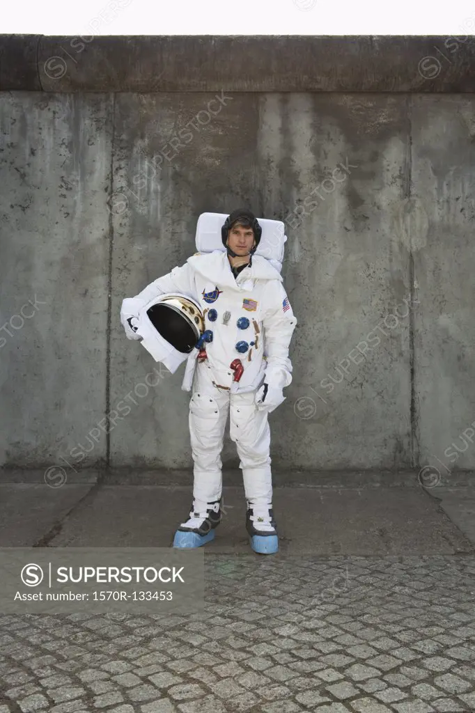 An astronaut standing on a sidewalk in a city