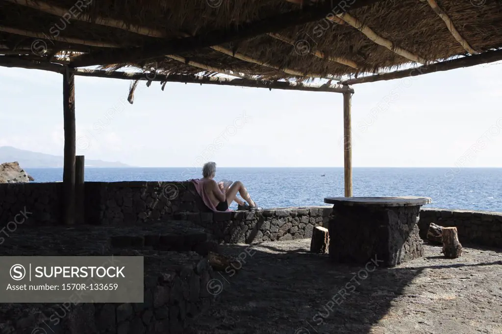 A man sitting in a beach hut by the sea
