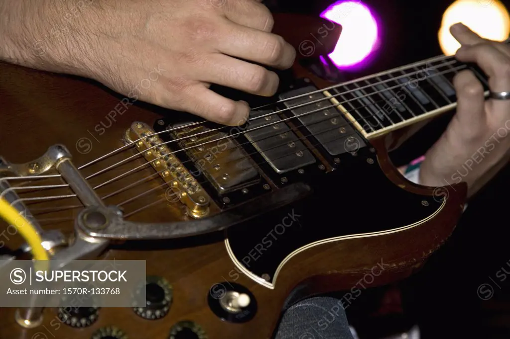 A man playing an electric guitar, close up of hands