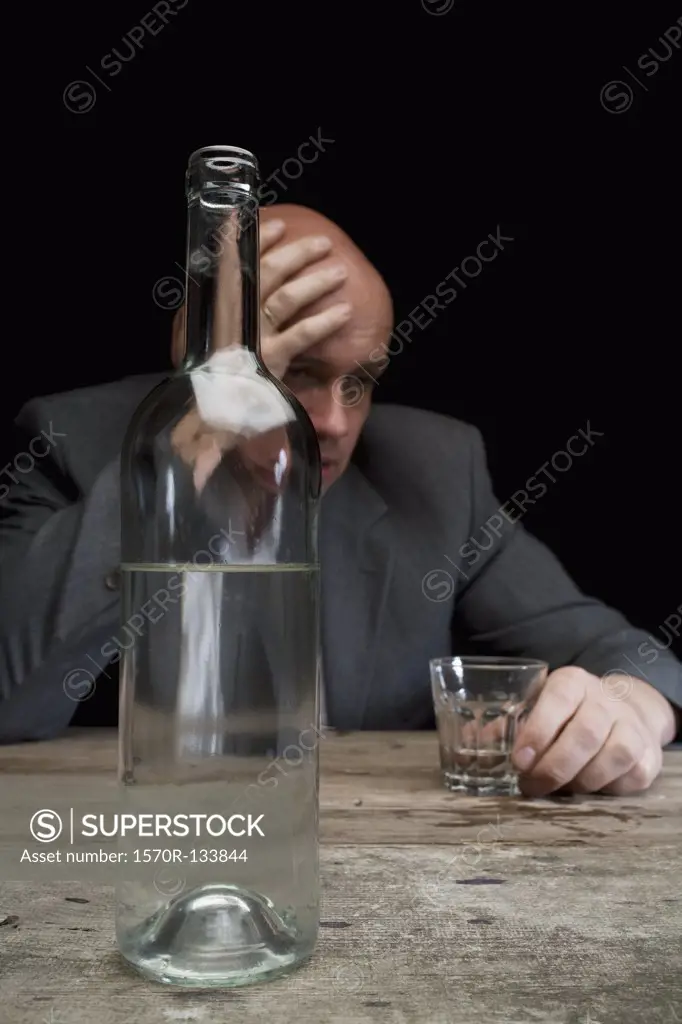 A drunk and depressed businessman holding a glass of vodka