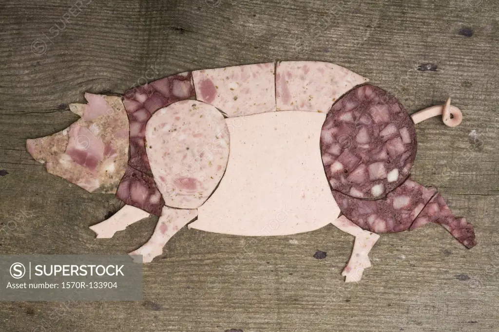 Cold cut meats arranged in the shape of a pig on wood