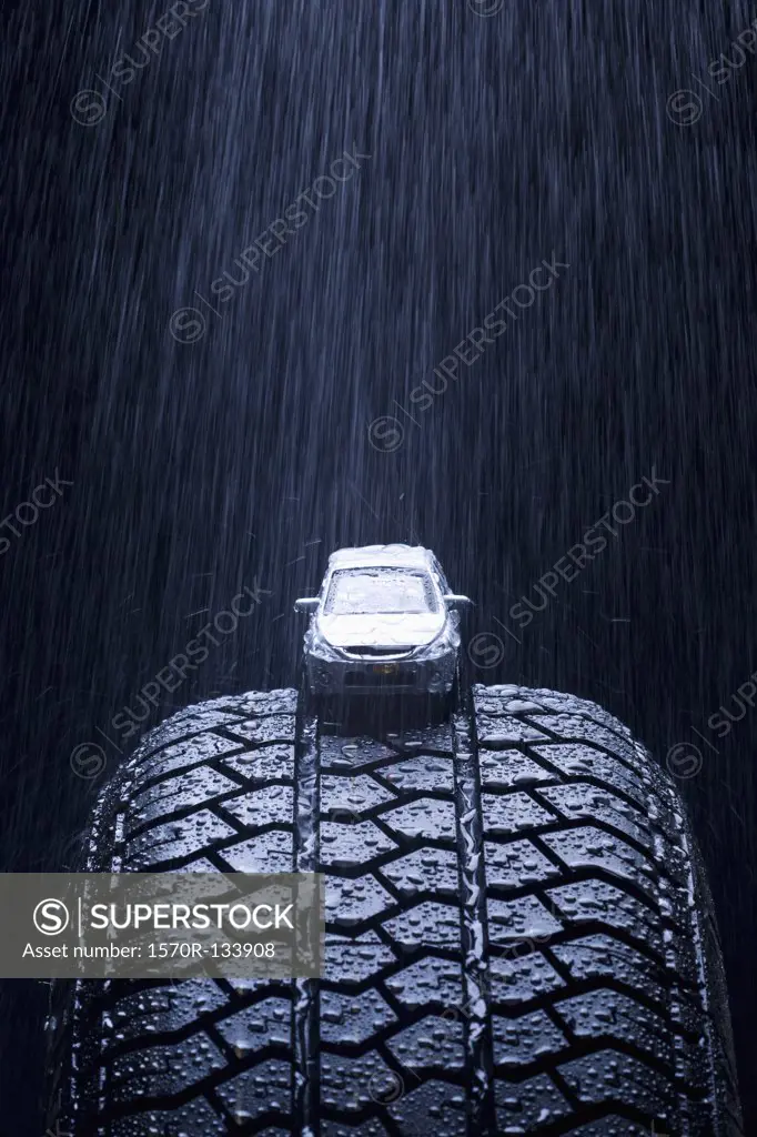 Detail of rain falling on a toy car on a tire