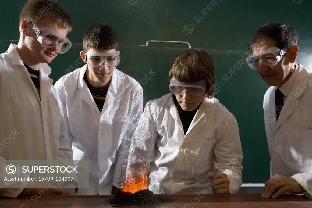 A teacher supervising students doing a chemistry experiment with lit gunpowder