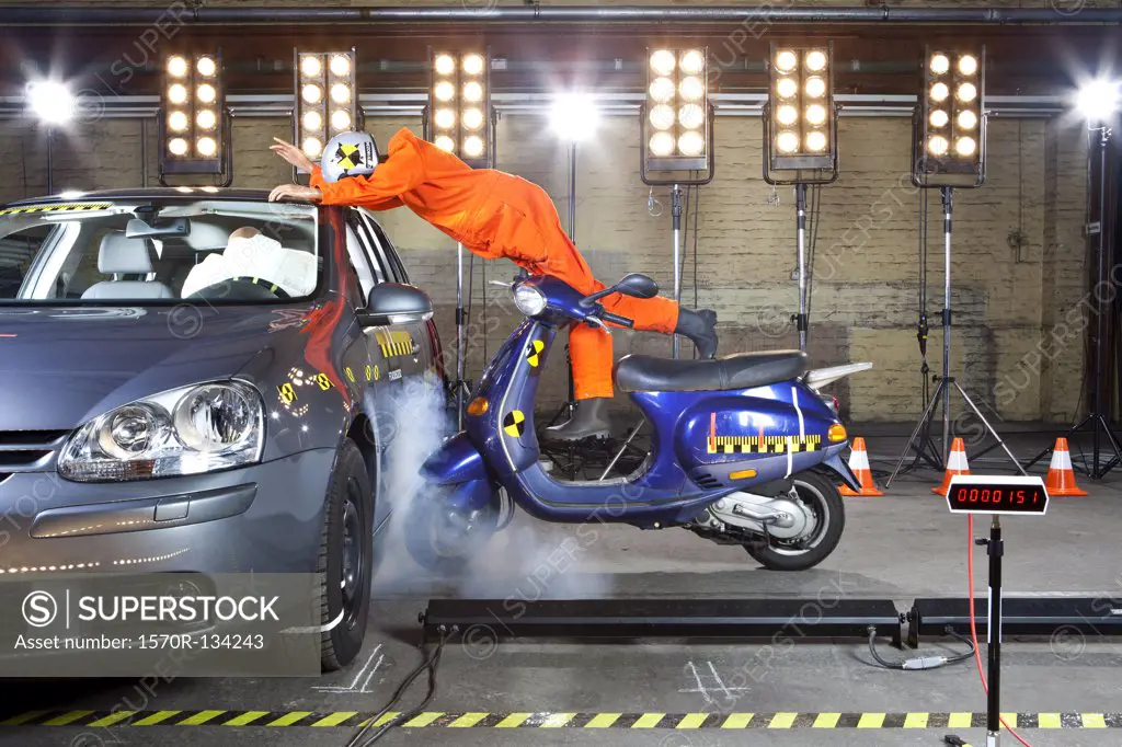 A crash test dummy on a scooter crashing into a car