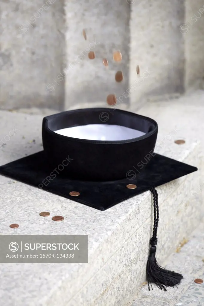 Copper coins falling into mortarboard