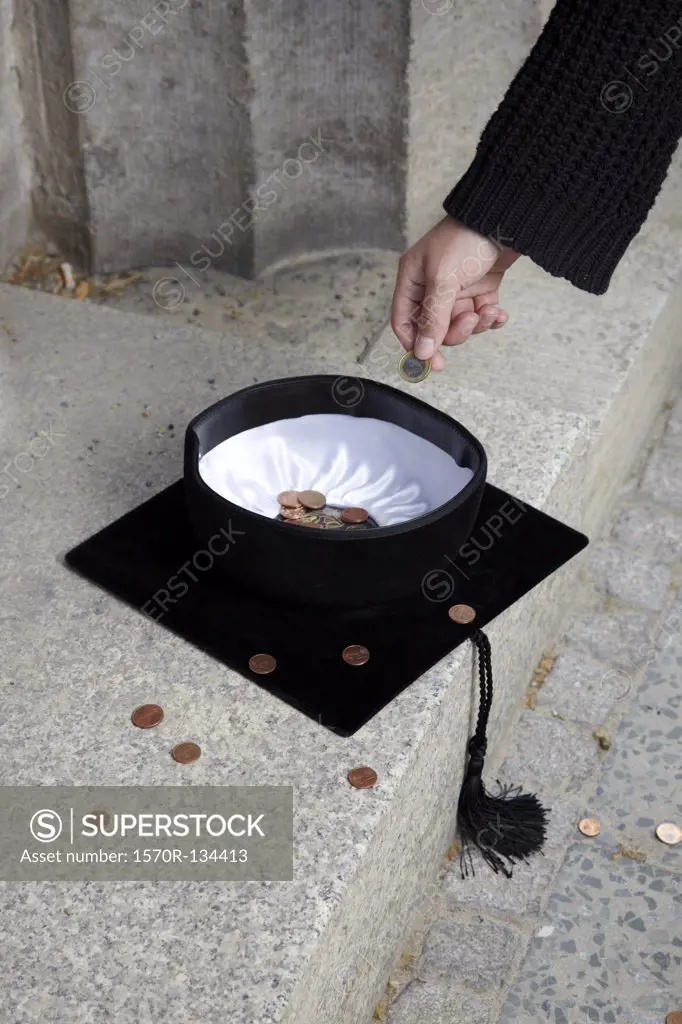 Man dropping coin into mortarboard