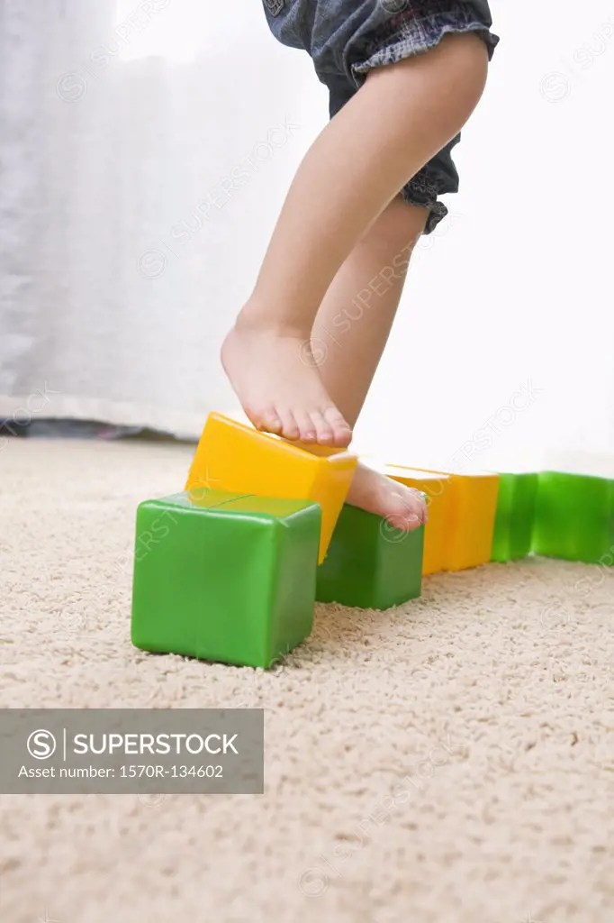 A girl balancing on top of toy blocks