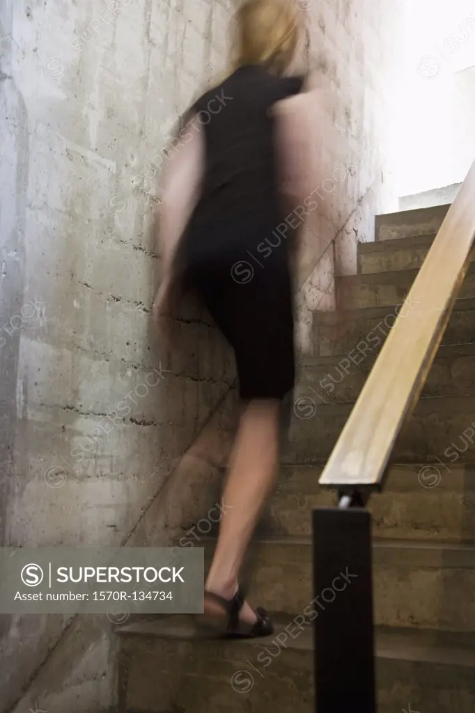Rear view of a woman walking up stairs