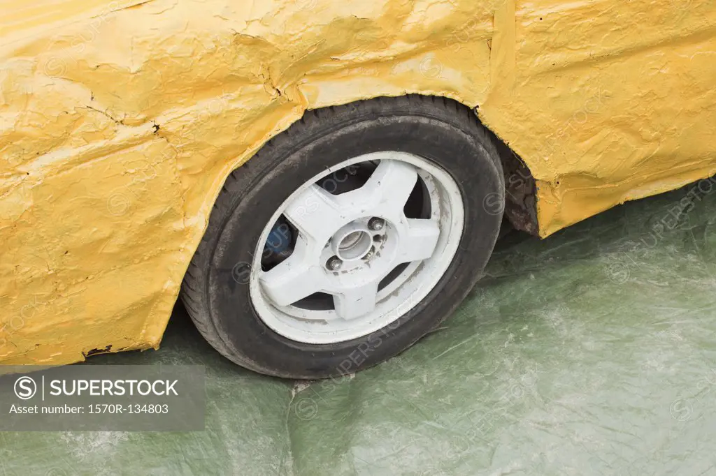Part of a damaged yellow car