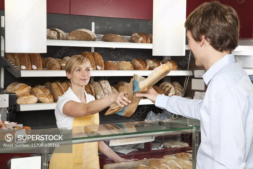 A sales clerk helping a customer at a bakery