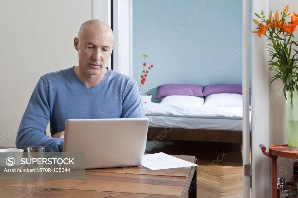 A man working on his laptop at home