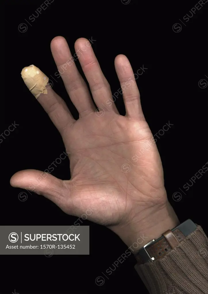 A man with a plaster on his finger, directly below, hand only