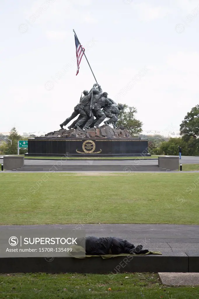 A homeless man sleeping in front of the Iwo Jima Memorial