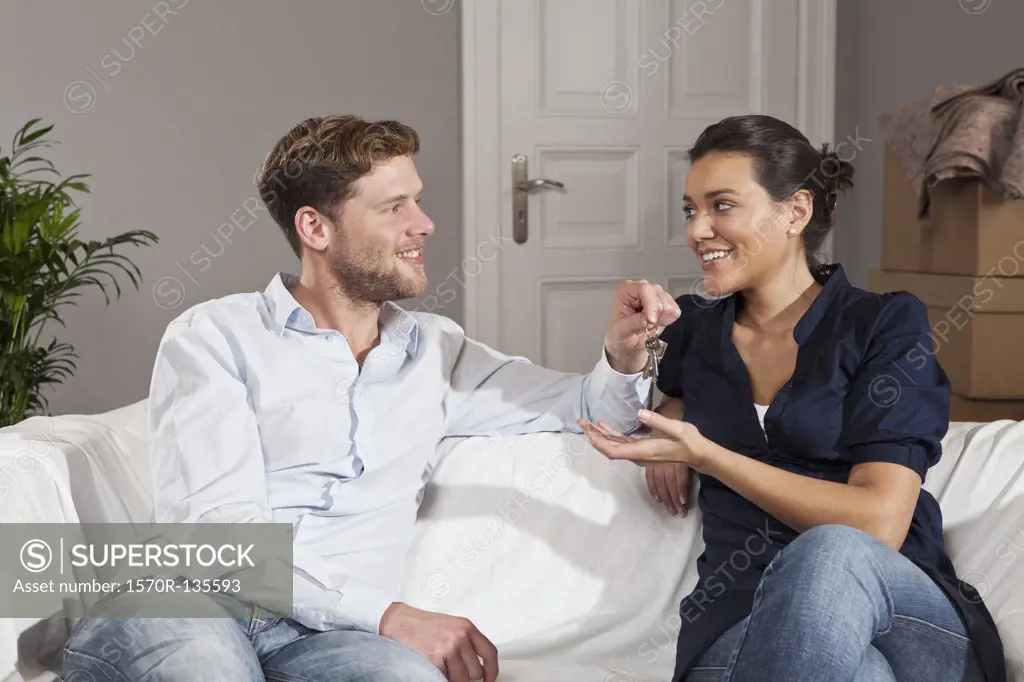 A man giving a woman a set of keys for their new house